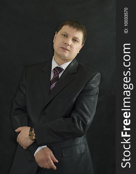 Closeup portrait of  handsome businessman over black background