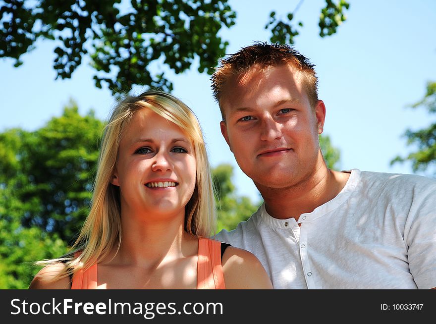 Young Couple sitting on Bench in the shadow. Young Couple sitting on Bench in the shadow