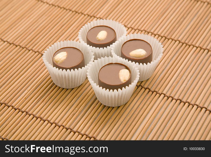 Four chocolate sweets on bamboo mat