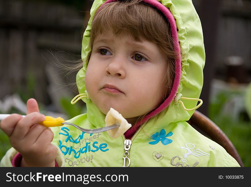 Little girl eating in the garden