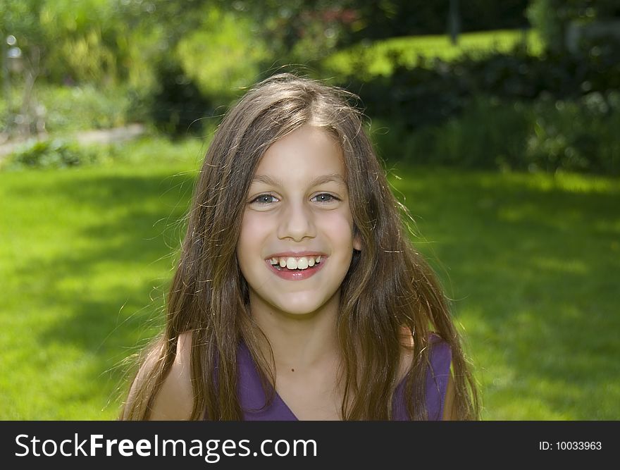 Portrait of preteen girl look and smile to camera in green garden. Portrait of preteen girl look and smile to camera in green garden