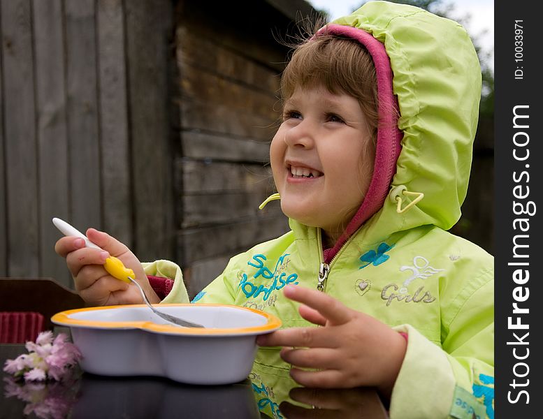 Little nice girl eating outdoors