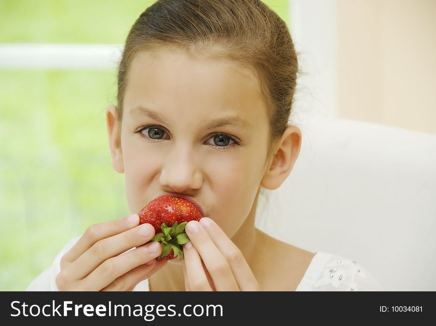 Close up face of pretty girl ,taking big strawberry with fingers and bite it while looking to camera. Close up face of pretty girl ,taking big strawberry with fingers and bite it while looking to camera