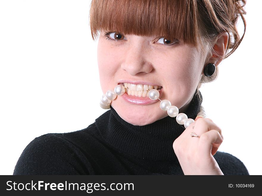 The emotional girl bites a necklace from pearls