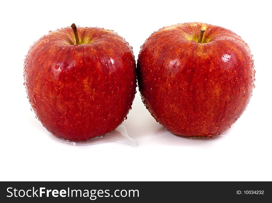 Two red apples with droplets isolated on a white background