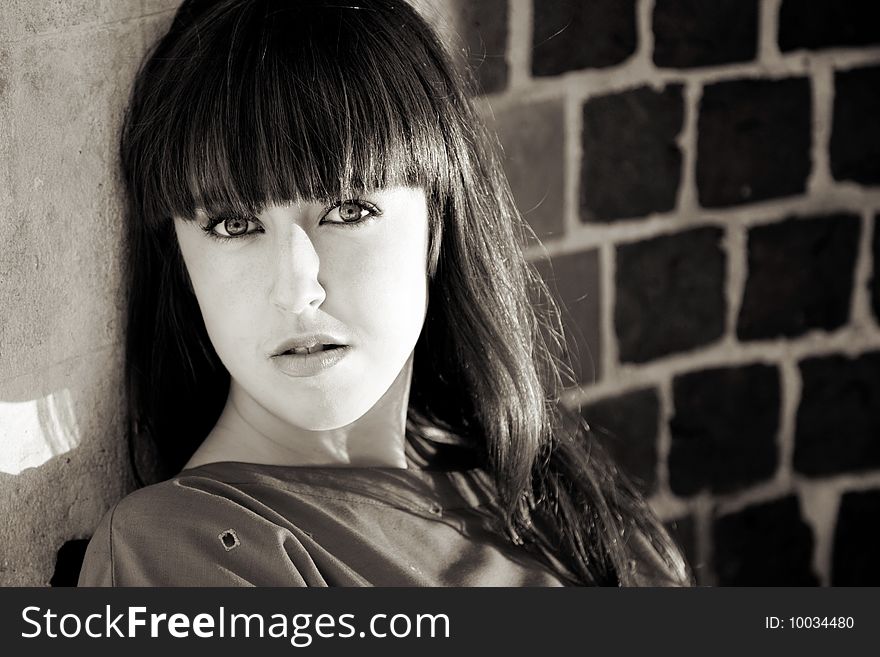 Portrait Om Beauty Woman Sitting against Brick Wall. Portrait Om Beauty Woman Sitting against Brick Wall