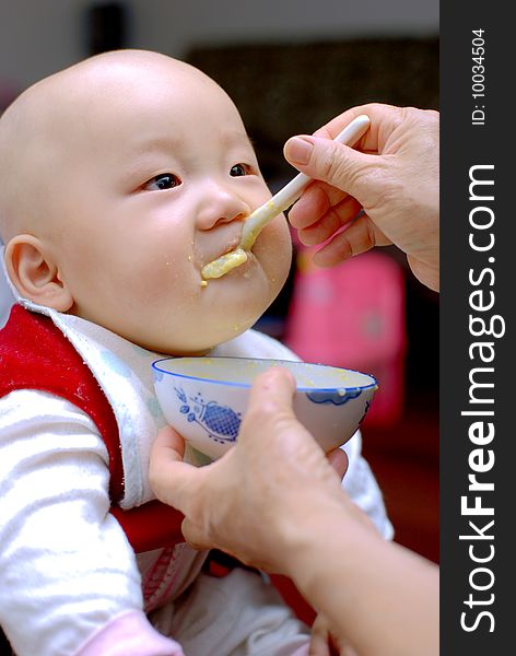 Baby with a spoon in a mouth. Baby with a spoon in a mouth