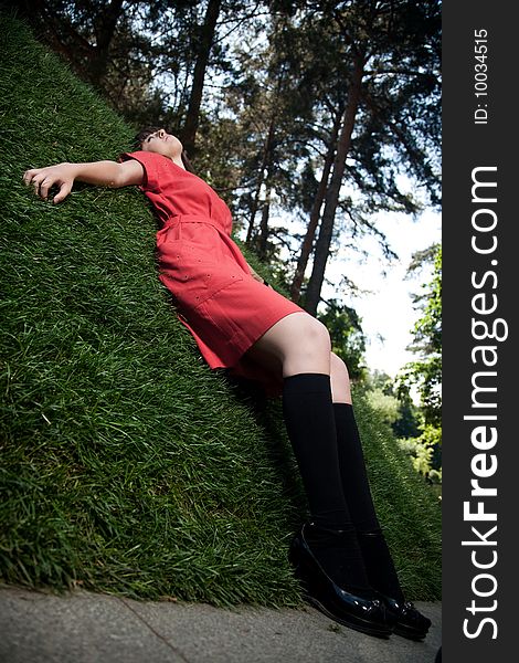 Woman In red Dress Laying On The Green Grass. Woman In red Dress Laying On The Green Grass