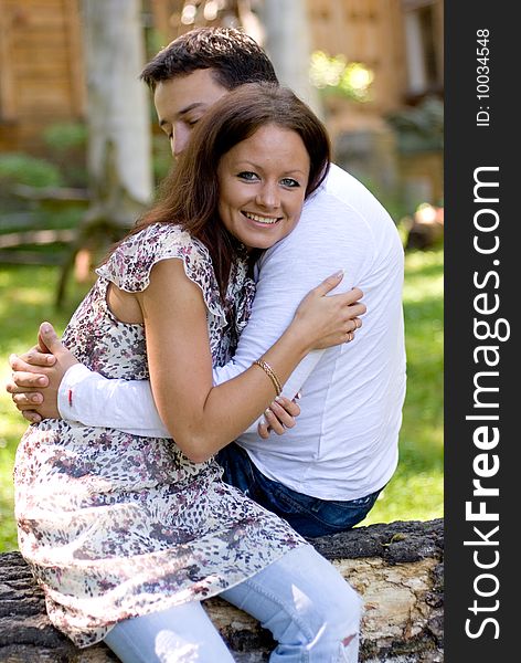 Woman with man sit on a tree to embrace each other. Woman with man sit on a tree to embrace each other