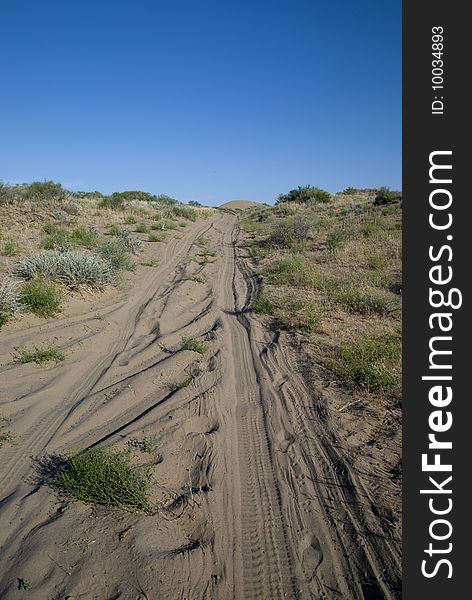 Road through the desert under a blue sky. Road through the desert under a blue sky