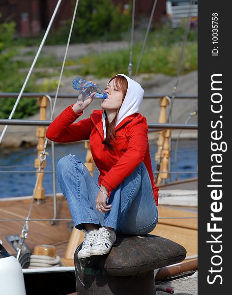 Woman sit on the coast and drinking water. Woman sit on the coast and drinking water