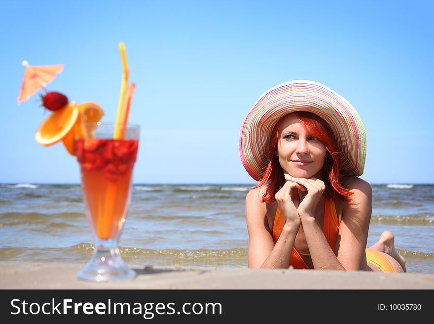 Young woman with fruit cocktail relaxing on beach. Young woman with fruit cocktail relaxing on beach