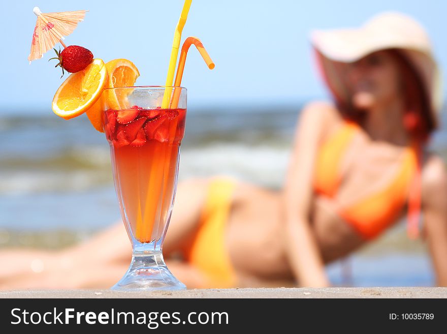 Young woman with fruit cocktail relaxing on beach. Young woman with fruit cocktail relaxing on beach