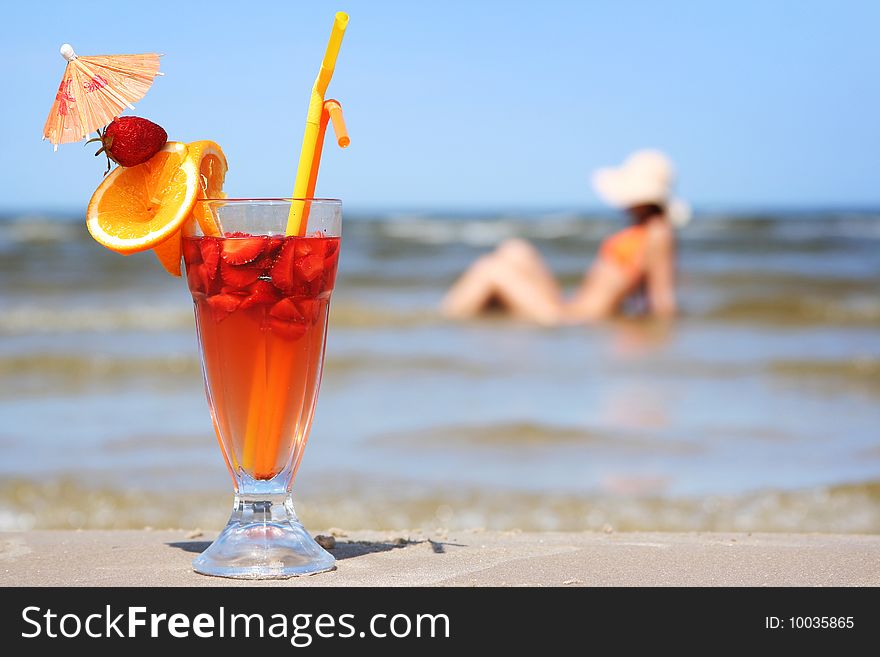 Young woman with fruit cocktail relaxing on beach. Young woman with fruit cocktail relaxing on beach