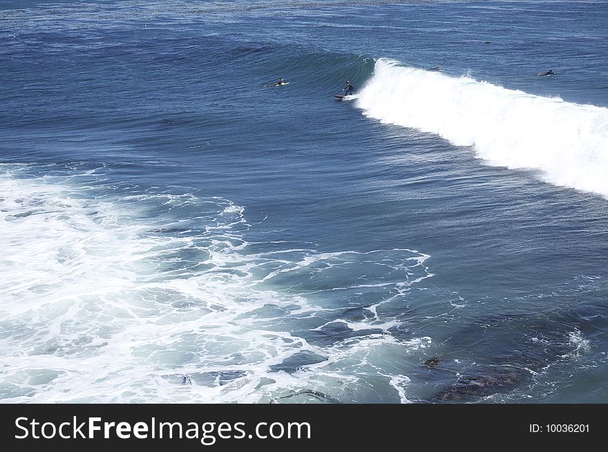 Ocean waves, some people surfing