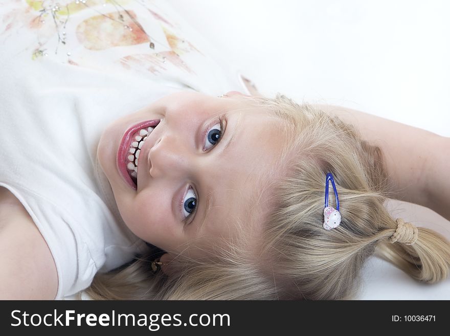 Young child lies smiling on the floor. Young child lies smiling on the floor