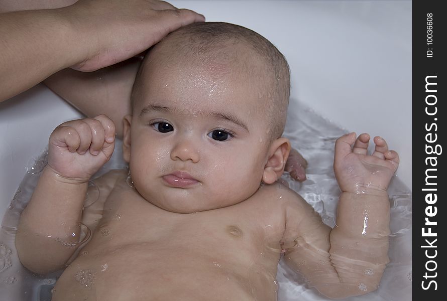 Baby is being taken bath in bath tube. Baby is being taken bath in bath tube