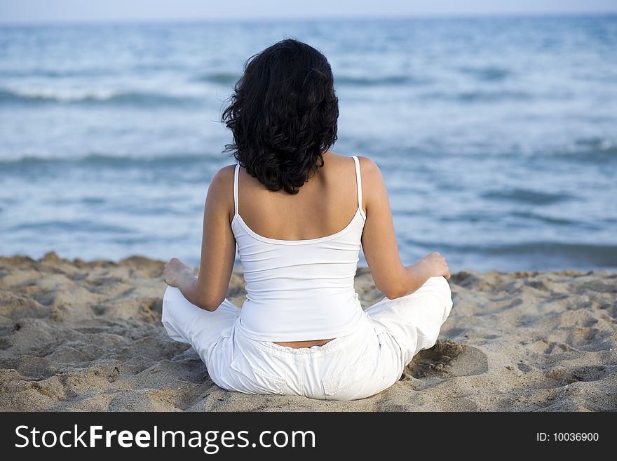 Woman making yoga exercise on the beach