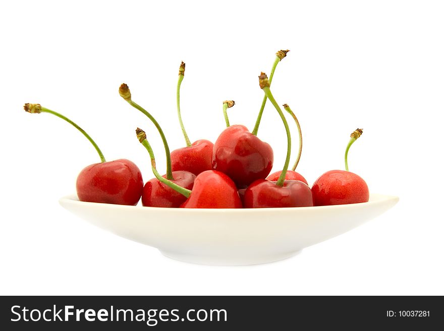 Group of ripe cherries on a white plate