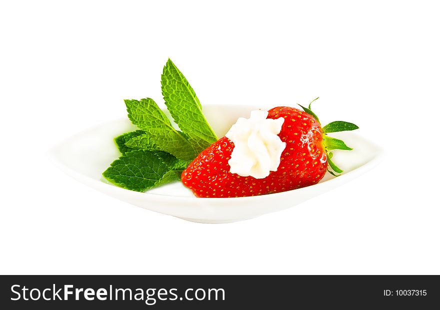 Ripe strawberry with cream on a white plate