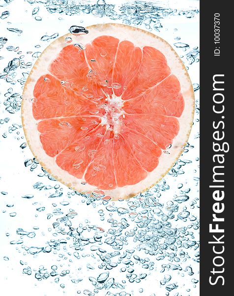 Red grapefruit in water. Creative fruit and bubbles water