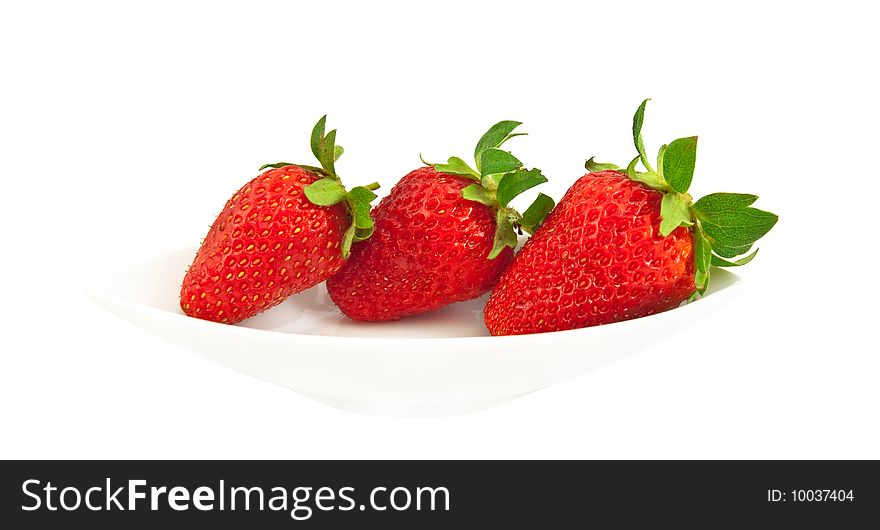 Three ripe strawberries on a white plate and a white background