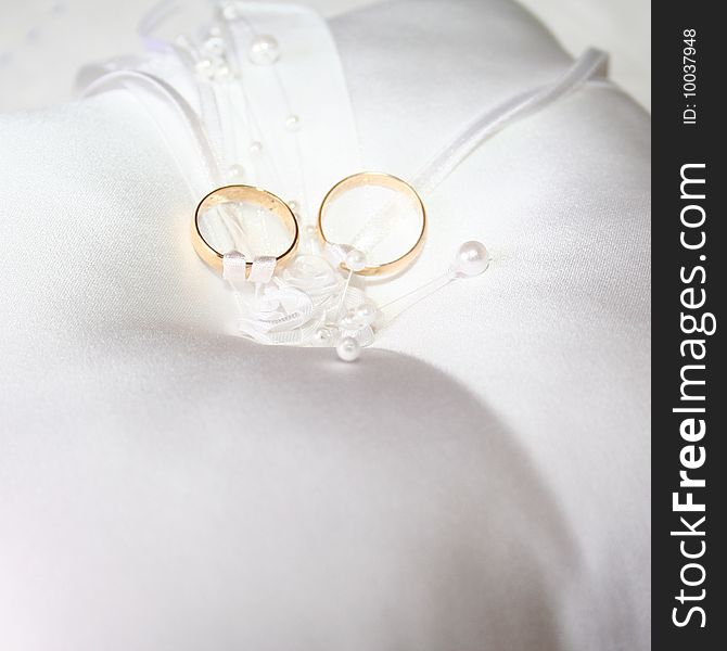 Set of wedding rings tied to a white lace pillow