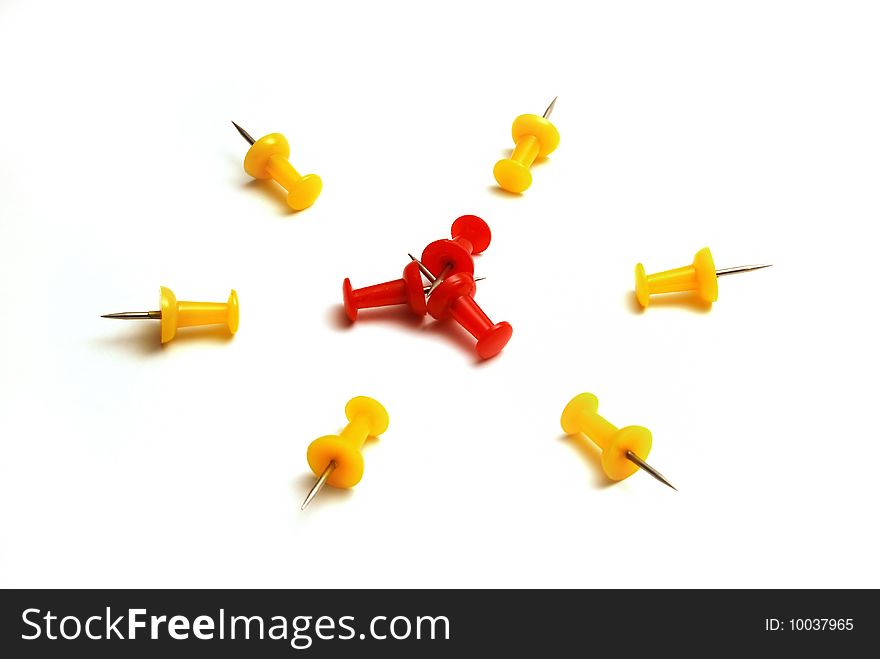 Red and yellow push pins on a white background