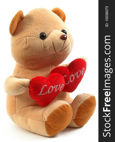 Teddy bear holding two hearts, isolated on white background.
