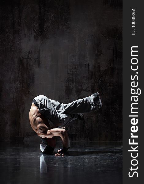 Modern style dancer posing on dirty grunge background. Modern style dancer posing on dirty grunge background