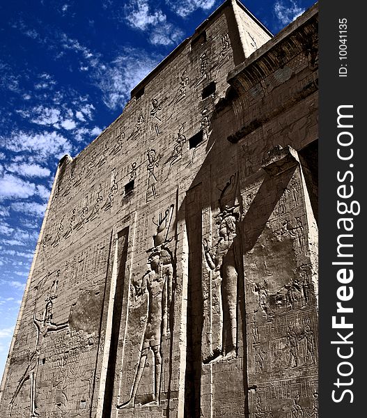 Edfu temple on the bank of the Nile river in Egypt with blue sky and clouds above