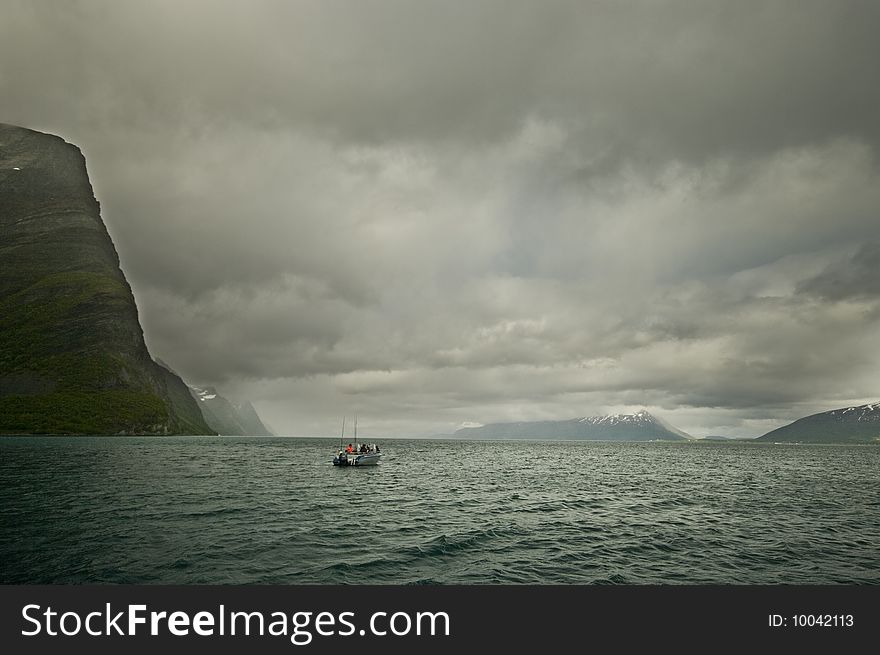 Lone motorboat, fishing on a north Norwegian fjord. Lone motorboat, fishing on a north Norwegian fjord.