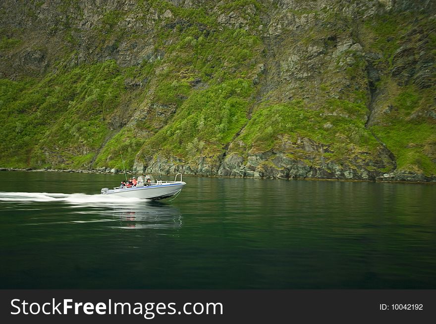 A motorboat speeding along a Norwegian fjord. A motorboat speeding along a Norwegian fjord.