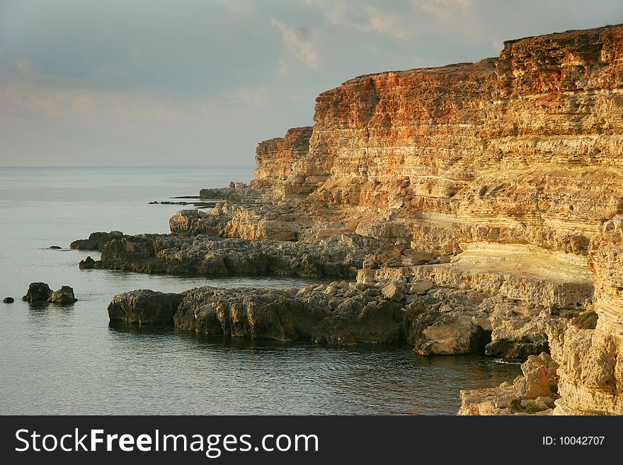 Steep rocky coast of the quiet silent sea a summer sunny day. Steep rocky coast of the quiet silent sea a summer sunny day