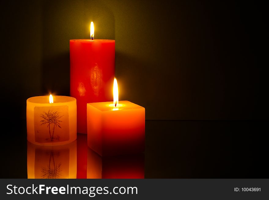 Three candles on green background