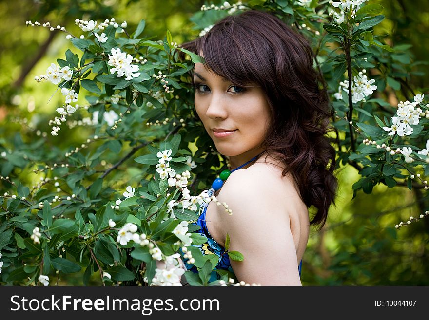 Tender girl in the garden with flowerings trees