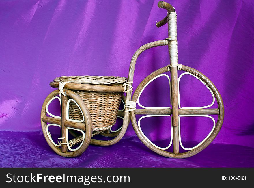 Wooden bicycle on a violet background