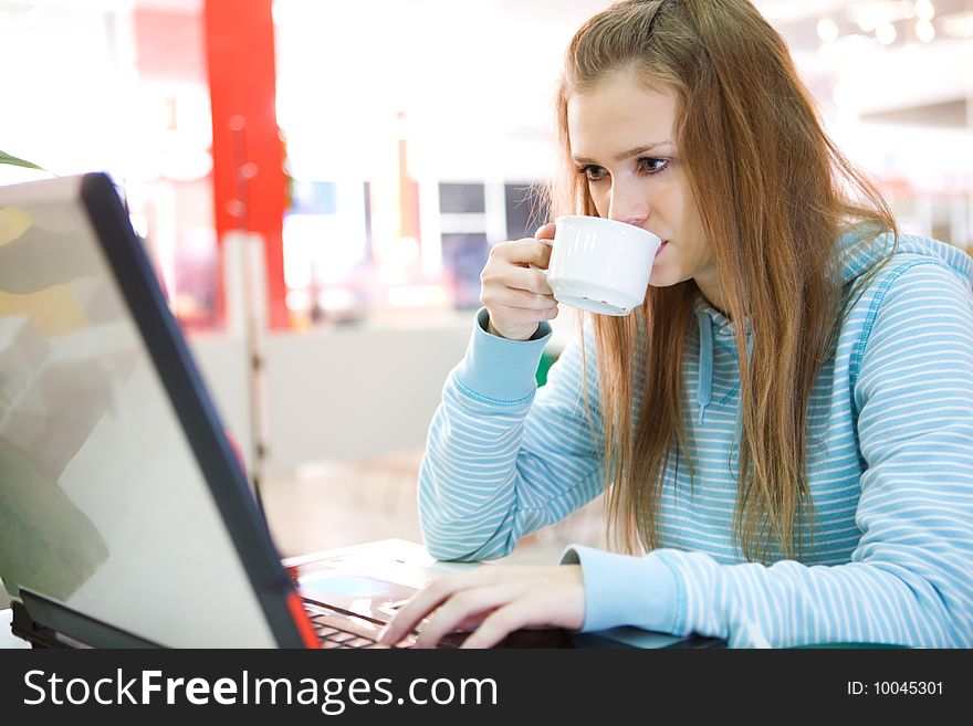 Young woman with laptop and coffee