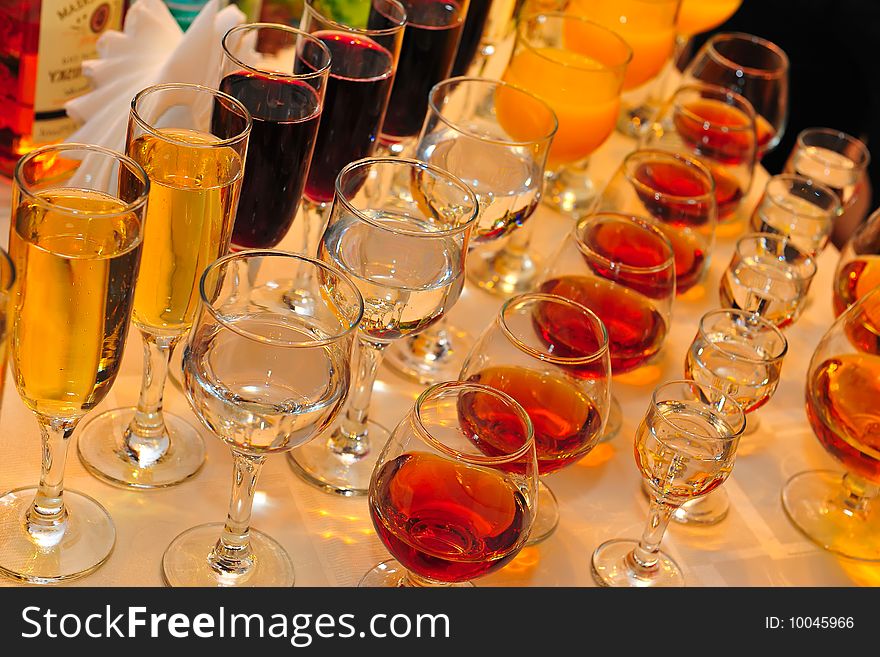 On a table stand with wine glasses, vodka, champagne and cognac. On a table stand with wine glasses, vodka, champagne and cognac