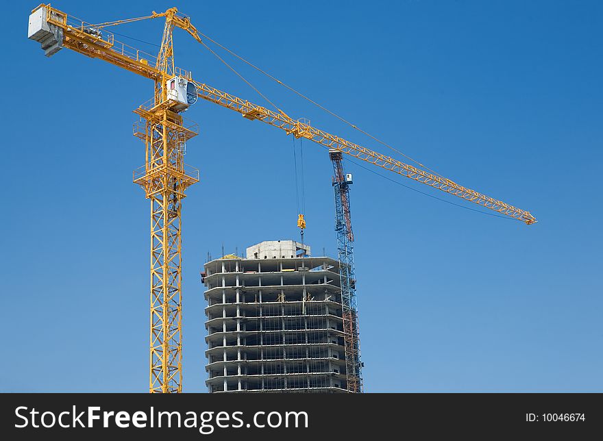Building with crane under blue sky with clouds