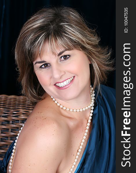 Beautiful mature female wrapped in fabric, wearing pearls