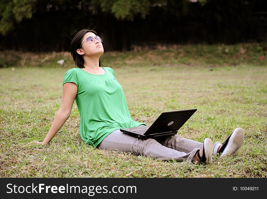 Asian girl does her business in the park as she soaks up some sun. Asian girl does her business in the park as she soaks up some sun.