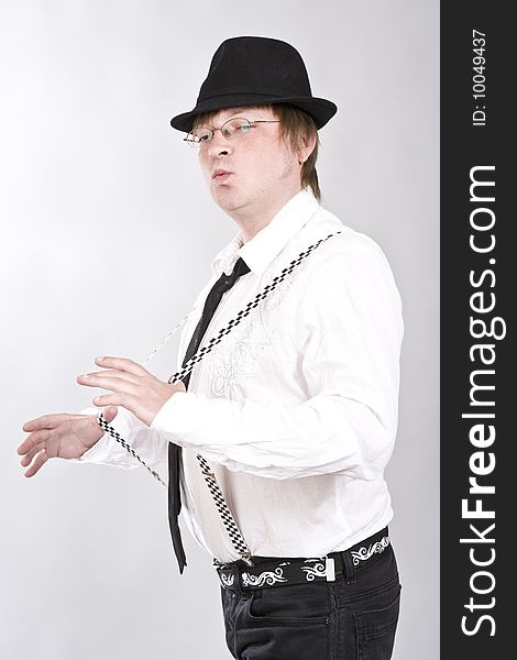 Man in a hat plays suspenders. Man in a hat plays suspenders