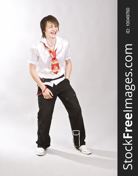 Full length of a happy young guy standing against
