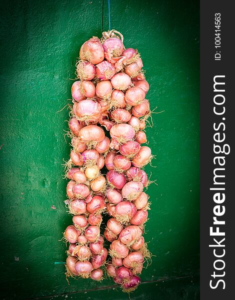 A hanging bag of onion with green background in morrocco