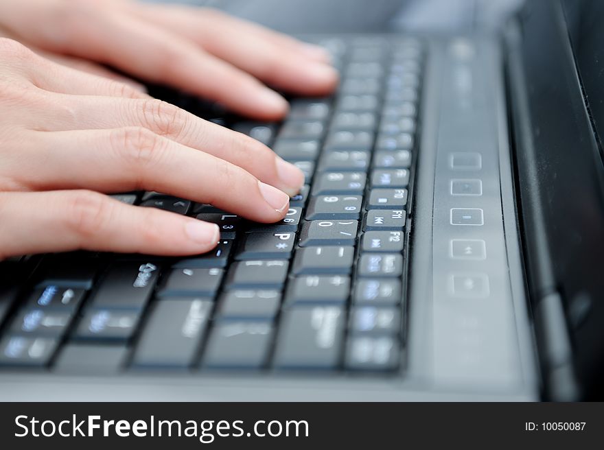 Female fingers type on a laptop. Female fingers type on a laptop.