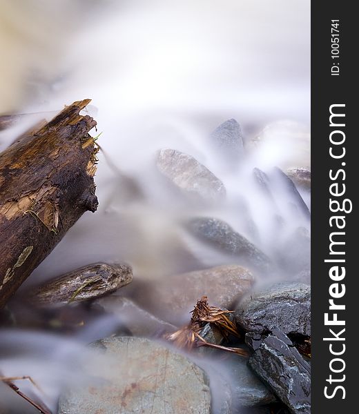 Beautiful view with flowing water. focus is on the old wood log. Beautiful view with flowing water. focus is on the old wood log.