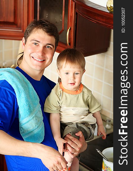 Happy father with his son on a kitchen at home. Happy father with his son on a kitchen at home.