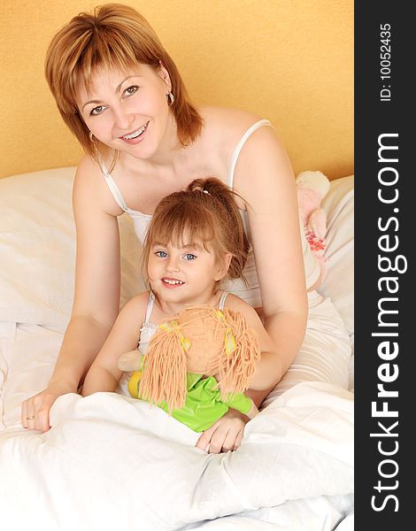 Portrait of a happy mother with her daughter in a bedroom. Portrait of a happy mother with her daughter in a bedroom.
