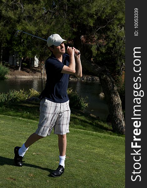 A golf player preparing to swing lining up shot. A golf player preparing to swing lining up shot